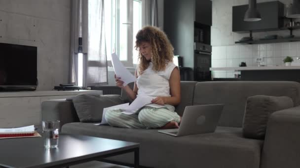一个高加索女人在家里读书 准备考试 人们坐在沙发上 手里拿着纸质文件或邮件 — 图库视频影像