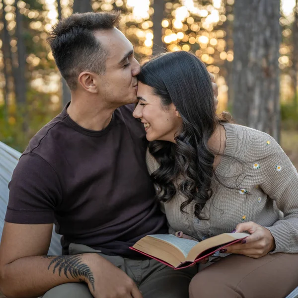 Man and woman young adult couple in nature hold and read book in love