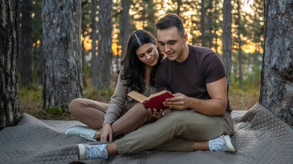 Erkek ve kadın, genç yetişkin bir çift, aşık olup kitap okuyorlar.