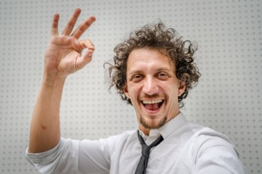 Kafkasyalı yetişkin bir adamın portresi açık havada durur beyaz gömlek giyer ve kravat takar mutlu bir gülümseme takınır fotokopi alanı duvarın önünde durur kendine güvenen bir işadamı modern binanın önünde poz verir.