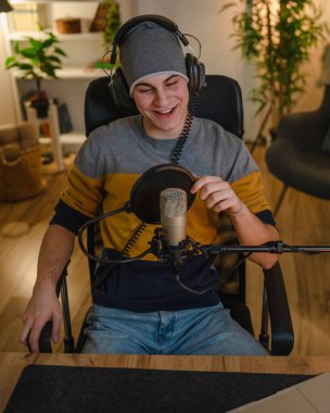 One man caucasian male blogger or vlogger gesticulating while streaming video podcast in broadcasting studio use microphone and headphones famous influencer shooting video for channel podcast