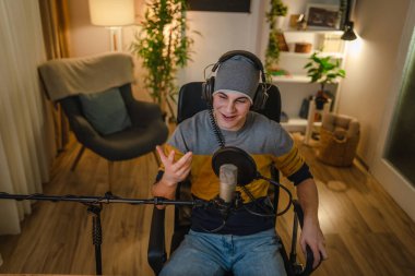 One man caucasian male blogger or vlogger gesticulating while streaming video podcast in broadcasting studio use microphone and headphones famous influencer shooting video for channel podcast