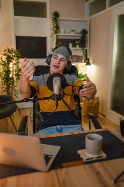 One man caucasian male blogger or vlogger gesticulating while streaming video podcast in broadcasting studio use microphone and headphones famous influencer shooting video for channel podcast