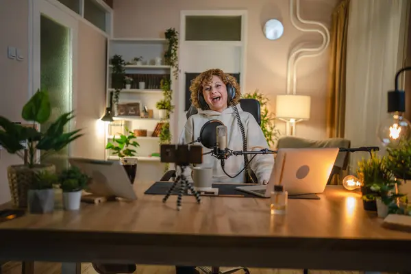 One woman caucasian female blogger or vlogger gesticulating while streaming video podcast in broadcasting studio use microphone and headphones famous influencer shooting video for channel podcast