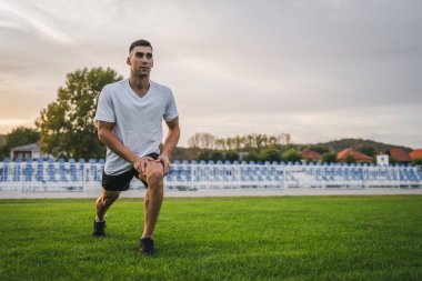 Bir erkek beyaz erkek atlet stadyum pistinde koşuyor ya da sonbahar ya da yaz sporlarında spor yapıyor spor yapıyor spor yapıyor sağlıklı yaşam tarzı kavramını gerçek insanlar taklit ediyor.