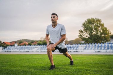 Bir erkek beyaz erkek atlet stadyum pistinde koşuyor ya da sonbahar ya da yaz sporlarında spor yapıyor spor yapıyor spor yapıyor sağlıklı yaşam tarzı kavramını gerçek insanlar taklit ediyor.