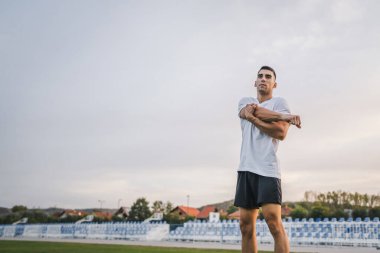 Bir erkek beyaz erkek atlet stadyum pistinde koşuyor ya da sonbahar ya da yaz sporlarında spor yapıyor spor yapıyor spor yapıyor sağlıklı yaşam tarzı kavramını gerçek insanlar taklit ediyor.