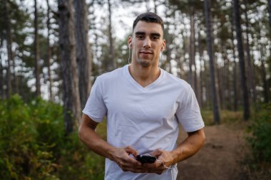 Sabah koşarken cep telefonu kullanan bir sporcunun portresi kulaklıkla müzik dinleyen atletik bir adam cep telefonu uygulaması kullanıyor