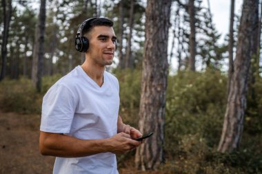 Sabah koşarken cep telefonu kullanan bir sporcunun portresi kulaklıkla müzik dinleyen atletik bir adam cep telefonu uygulaması kullanıyor