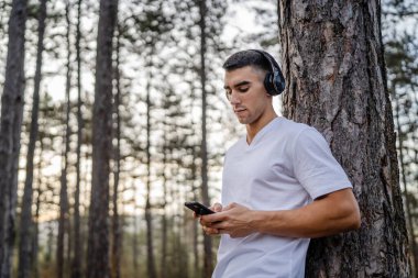 Sabah koşarken cep telefonu kullanan bir sporcunun portresi kulaklıkla müzik dinleyen atletik bir adam cep telefonu uygulaması kullanıyor