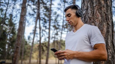 Sabah koşarken cep telefonu kullanan bir sporcunun portresi kulaklıkla müzik dinleyen atletik bir adam cep telefonu uygulaması kullanıyor