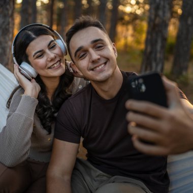 Doğadaki erkek ve kadın yetişkin çift kendi portresini çekerler. Çirkin resim. Cep telefonu kullanırlar ya da video görüşmesi yaparlar.