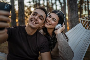 Doğadaki erkek ve kadın yetişkin çift kendi portresini çekerler. Çirkin resim. Cep telefonu kullanırlar ya da video görüşmesi yaparlar.