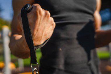 Yetişkin beyaz bir adam, günlük egzersiz rutininde lastik elastik direnç tüpleri kullanarak şehir dışında antrenman yapıyor. Gerçek insan sağlığı ve fitness konsepti kopyalama alanı kullanıyor.