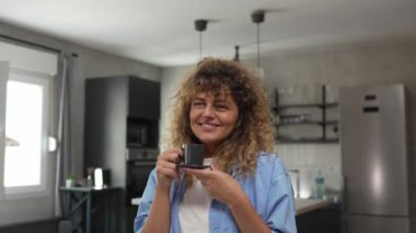 Yetişkin beyaz bir kadının portresi. Mutlu, kıvırcık saçlı.