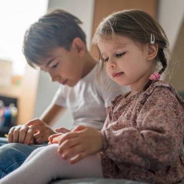 Ağabey kız kardeşle akıllı telefon kullan. Çocuklar evde cep telefonu kullan. Video izle, ara ya da oyun oyna.