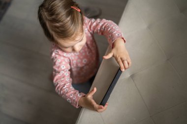 Bir beyaz çocuk cep telefonunu evde tutuyor video oyunları oynuyor ve büyüyen teknoloji bağımlılığı kavramı online tarama veya video izlemek için uygulama kullanıyor