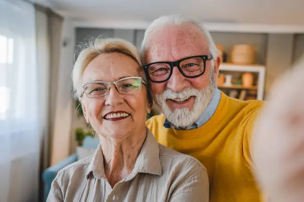 Portrait of senior husband and wife happy caucasian man and woman old couple at home taking selfie self portrait