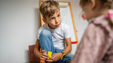 Small caucasian boy and girl siblings brother and sister children play at home sit on the floor at home childhood development growing up concept copy space domestic life