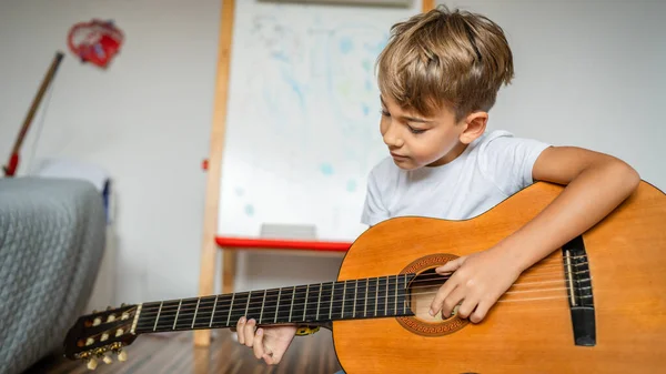 Roztomilý Chlapec Učí Hrát Klasickou Kytaru — Stock fotografie