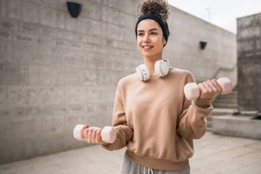Yetişkin Kafkasyalı kadın, günlük antrenmanında halterli ağırlık kullanan kadın sporcu. Gerçek insan sağlığı ve zindelik konsepti uzay fotokopisi.