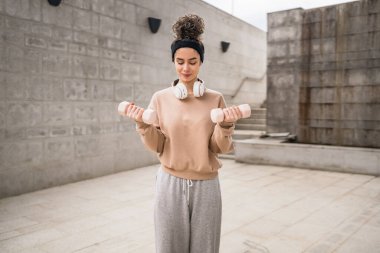 Yetişkin Kafkasyalı kadın, günlük antrenmanında halterli ağırlık kullanan kadın sporcu. Gerçek insan sağlığı ve zindelik konsepti uzay fotokopisi.