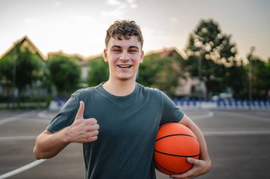 Kafkas asıllı bir genç adam basketbol sahasında duruyor. Akşamları elinde top, fotokopi çekmeye hazır. Gerçek insan.