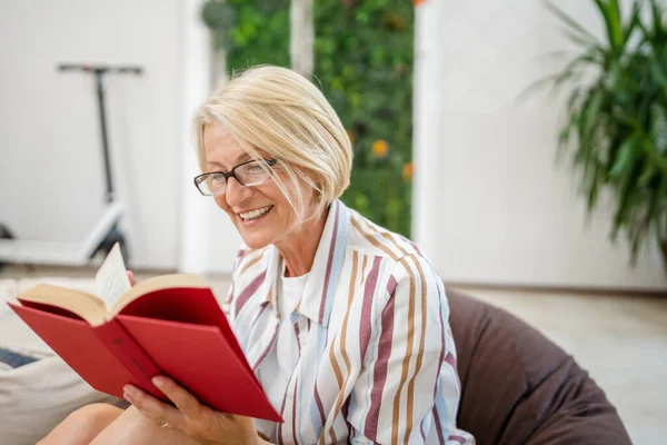 Bir Kadın Olgun Beyaz Kadın Aydınlık Odada Modern Kitap Okuyor — Stok fotoğraf