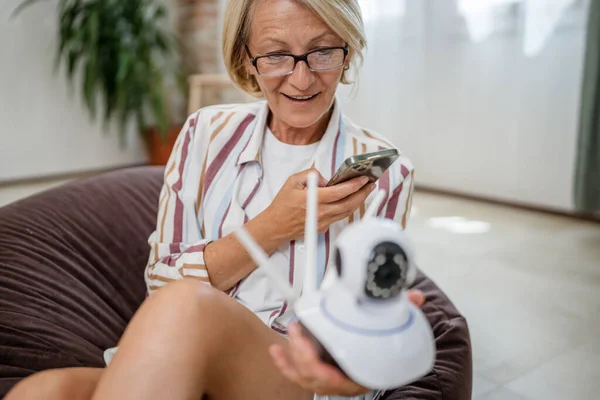 Yetişkin Bir Beyaz Kadın Modern Güvenlik Kamerası Cep Telefonunu Elinde — Stok fotoğraf