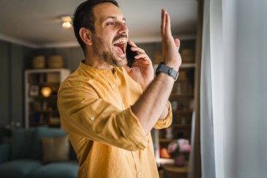 Yetişkin bir beyaz erkek cep telefonuyla arama yapar. Mutlu bir gülümseme, tişört ve gözlük takar. Gerçek bir insanı taklit eder.