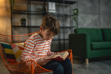 Evdeki beyaz bir çocuk akşam manzaralı bir kitap okudu. Gerçek insanların eğitim konseptini kopyaladı.