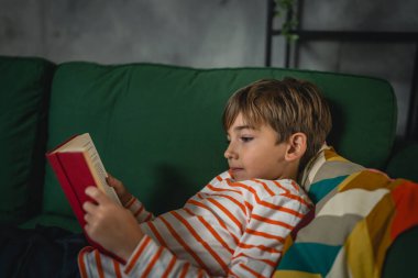 Evdeki beyaz bir çocuk akşam manzaralı bir kitap okudu. Gerçek insanların eğitim konseptini kopyaladı.