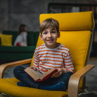 Evdeki beyaz bir çocuk akşam manzaralı bir kitap okudu. Gerçek insanların eğitim konseptini kopyaladı.