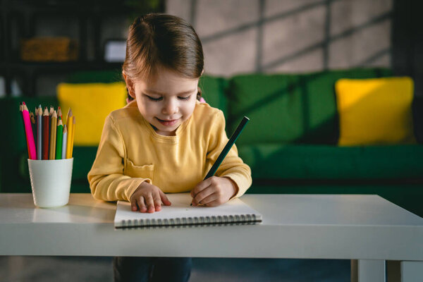 Toddler girl caucasian child play with crayons at home