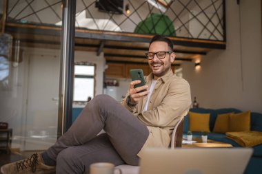 Beyaz, sakallı ve evde yaşayan bir erkek cep telefonu kullanarak SMS mesajları, internet ve video arama uygulamaları kullanıyor.