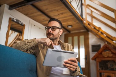 Kafkasyalı Kafkasyalı Dijital Tablet evde çalışıyor. Endişeli olduğunu düşün.