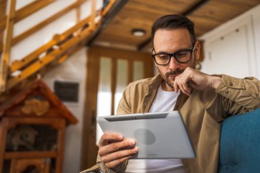 Kafkasyalı Kafkasyalı Dijital Tablet evde çalışıyor. Endişeli olduğunu düşün.