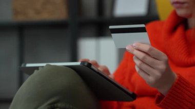 Close up on hand of unknown woman hold credit card shopping online