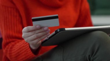 Close up on hand of unknown woman hold credit card shopping online