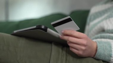 Close up on hand of unknown woman hold credit card shopping online