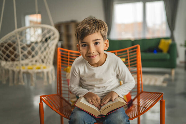 One boy caucasian child seven years old kid in room at home read book