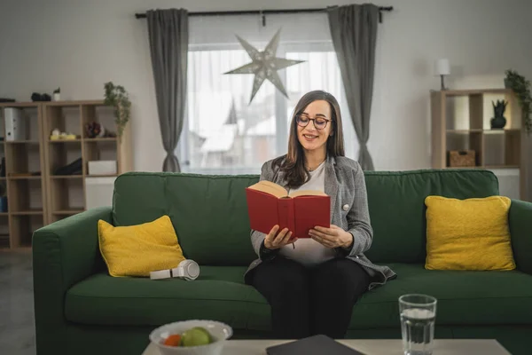 one pregnant woman read book at home
