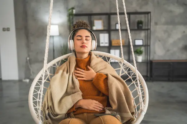 stock image one woman adult caucasian female millennial using headphones for online guided meditation practicing mindfulness yoga with eyes closed at home real people self care concept copy space