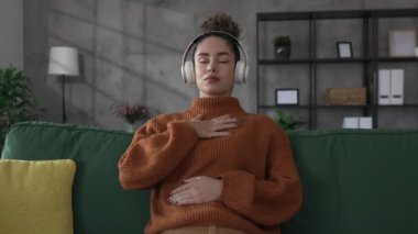 Yetişkin bir kadın Kafkasyalı kadın meditasyon yapıyor milenyum meditasyonu evde gözleri kapalı farkındalık yogası yapıyor gerçek insanlar kişisel bakım kavramını kopyalıyor.