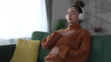 Yetişkin bir kadın Kafkasyalı kadın meditasyon yapıyor milenyum meditasyonu evde gözleri kapalı farkındalık yogası yapıyor gerçek insanlar kişisel bakım kavramını kopyalıyor.