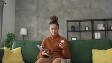 Kadın ilaç tutuyor vitamin takviyesi şişesi hapları etiketi okuyor.