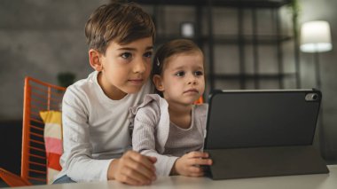 Erkek ve kız kardeş küçük kardeşler evde dijital tablet kullanıyorlar online video izliyorlar
