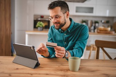 İnternet üzerinden alışveriş yapan yetişkin bir adam internet üzerinden kredi kartı kullanıyor e-bankacılık internet üzerinden e-ticaret yapıyor