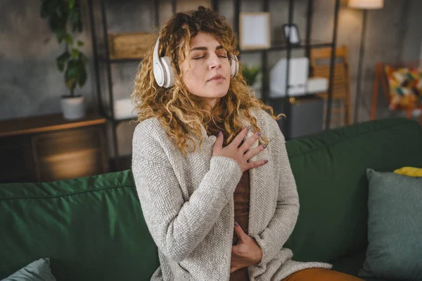 1人の女性の大人の慎重な女性ミレニアルオンラインガイド瞑想のためのヘッドフォンを使用してマインドフルネスヨガの目を閉じた本物の人々セルフケアコンセプトコピースペース — ストック写真