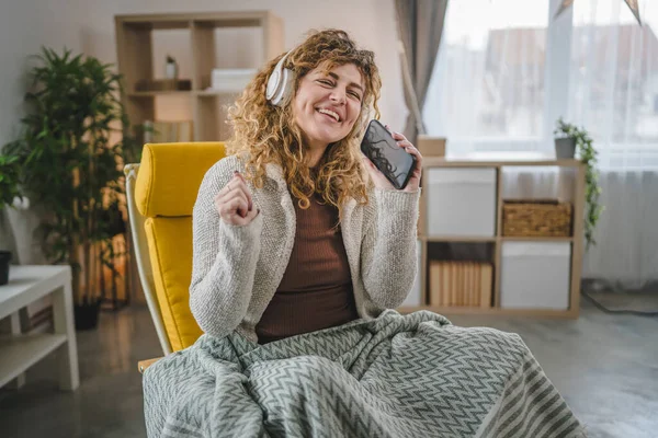 Kafkasyalı Kulaklıklı Yetişkin Bir Kadın Evde Cep Telefonu Ile Müzik — Stok fotoğraf